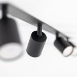 Lampa sufitowa podtynkowa Nex z czterema punktami świetlnymi GU10. Czarna konstrukcja z cylindrycznymi kloszami, zamontowana na prostokątnej podstawie. Ujęcie z dołu, ukazujące detale i fakturę materiału.