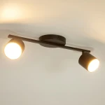 Czarna lampa sufitowa Mila z dwoma reflektorami na metalowym stelażu. Reflektory są okrągłe z białym wnętrzem, skierowane na zewnątrz. Lampa montowana na suficie, o minimalistycznym designie, idealna do oświetlenia wnętrz.