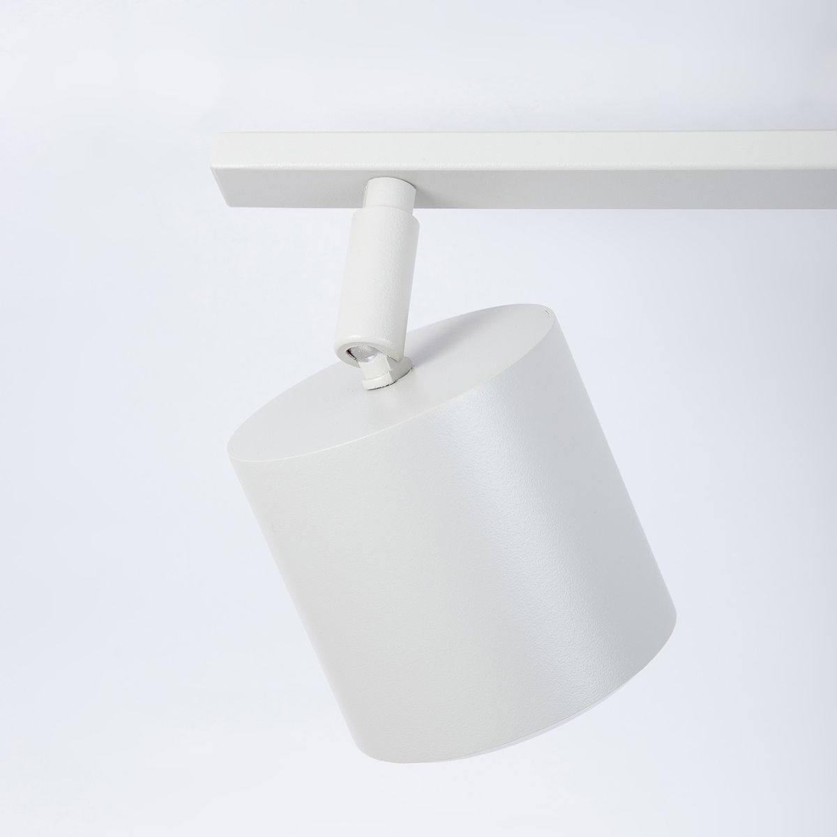Mila lampa sufitowa (spot) 2xGX53 w kolorze szarym beżowym, z cylindryczną głowicą na ruchomym ramieniu, zamontowana na prostokątnej podstawie. Ujęcie z boku, pokazujące detal obudowy oraz mechanizm mocowania.