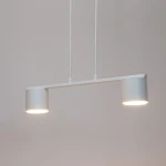 Lampa wisząca Mila 2xGX53 w kolorze białym, składająca się z dwóch cylindrycznych kloszy zamocowanych na poziomej ramie. Klosze emitują światło, a lampa zawieszona jest na dwóch białych przewodach. Prosta, nowoczesna forma.