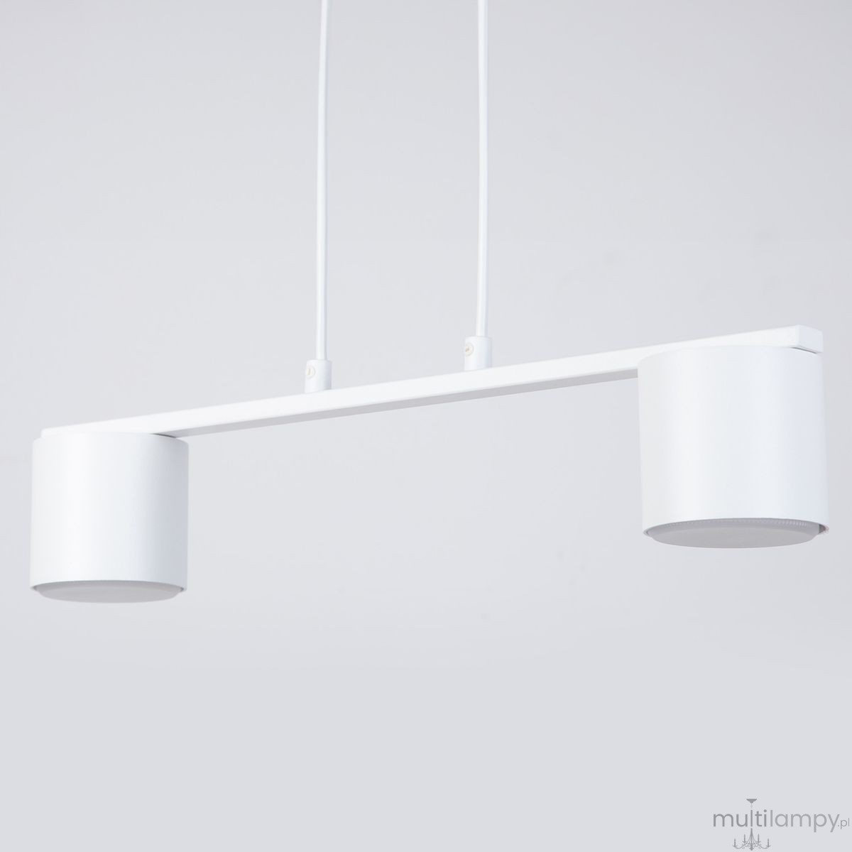 Lampa wisząca Mila w kolorze białym z dwoma źródłami światła GX53. Prosta, minimalistyczna konstrukcja z metalowym ramieniem i cylindrycznymi kloszami. Ujęcie frontalne, zawieszona na dwóch przewodach, na jednolitym tle.