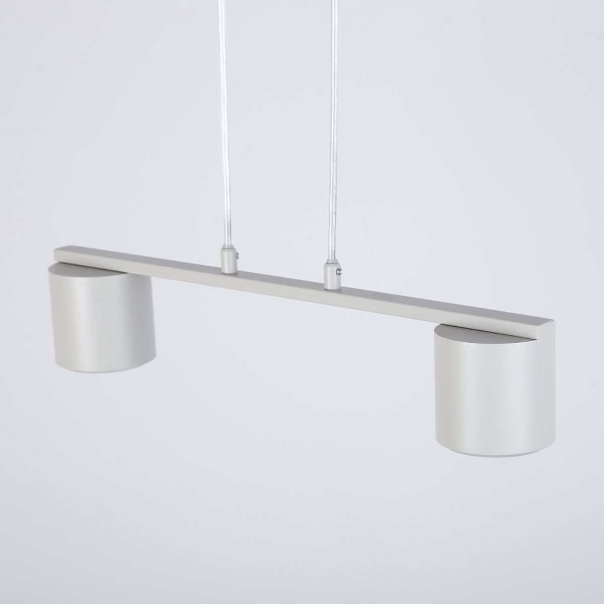 Lampa wisząca Mila w odcieniu szaro-beżowym z dwoma oprawami na żarówki GX53. Posiada prostą, metalową konstrukcję z poziomą belką i dwoma okrągłymi kloszami. Zawieszona na cienkich linkach, idealna do nowoczesnych wnętrz.