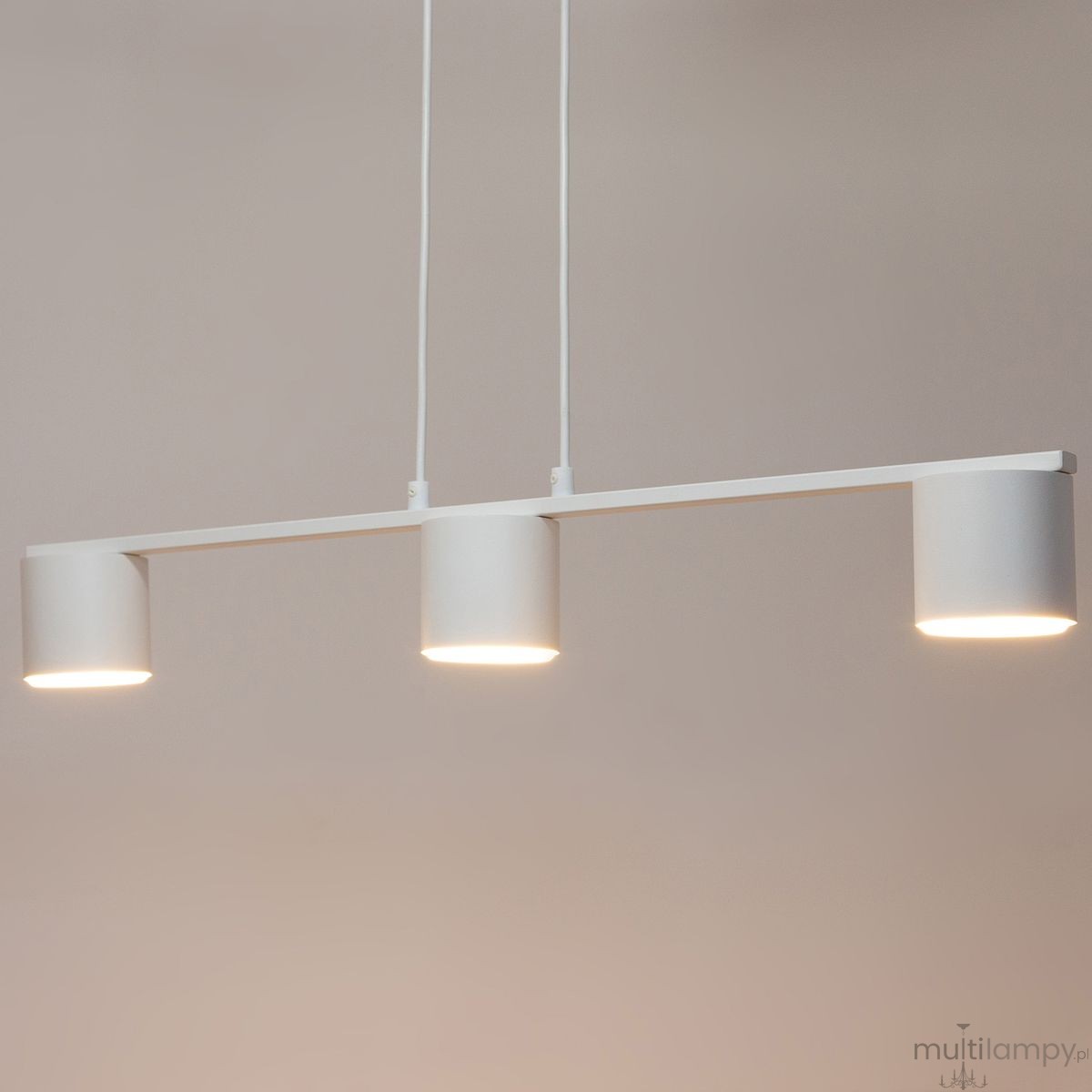 Lampa wisząca Mila z trzema punktami świetlnymi w kolorze białym. Prosty, minimalistyczny design z cylindrycznymi kloszami zawieszonymi na cienkich linkach. Widok z przodu, na jednolitym tle.