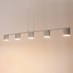 Lampa wisząca Mila w kolorze szarym beż, składająca się z pięciu okrągłych źródeł światła, zawieszona na cienkich linkach. Prosty, nowoczesny design, z równomiernym rozłożeniem lamp, idealna do oświetlenia wnętrz.