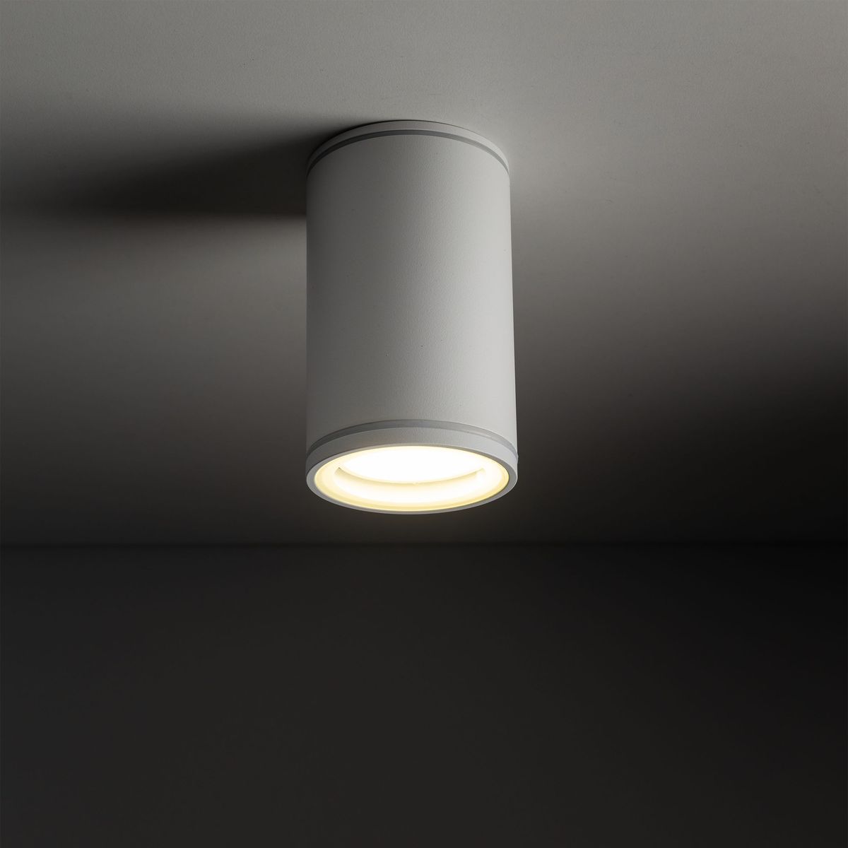 Lampa sufitowa Flare w kolorze białym, cylindryczna, z jedną oprawą na żarówkę GU10. Montowana na suficie, z widocznym źródłem światła. Wysoka klasa ochrony IP44, odpowiednia do użytku w wilgotnych pomieszczeniach.