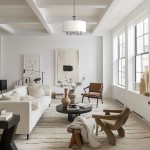 Lampa wisząca Abu Dhabi 5-punktowa w chromie, z białym abażurem, zawieszona na łańcuchu, w jasnym wnętrzu z nowoczesnym umeblowaniem. Widoczna w kontekście aranżacji salonu z kanapą, stolikiem i dekoracjami.