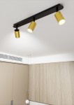 Czarna lampa sufitowa 3-punktowa Zen z metalowymi kloszami w kolorze złotym. Ujęcie z dołu, produkt zamontowany na suficie, skierowany w dół. Tło w jasnych odcieniach, z widocznymi elementami wnętrza.