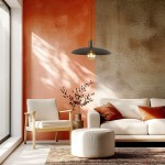 Lampa wisząca Astra w kolorze brązowym, z pojedynczym gniazdem E27, zawieszona nad sofą w jasnym wnętrzu. W tle widoczna ściana w odcieniach pomarańczowego i szarego, z naturalnym światłem wpadającym przez okno.