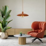 Lampa wisząca Astra w kolorze ceglastym z oprawą na żarówkę E27. Okrągły klosz z metalu wisi na cienkim przewodzie. W tle widoczna stylowa, czerwona sofa oraz roślina doniczkowa, co tworzy nowoczesną aranżację wnętrza.