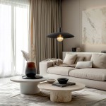 Czarna lampa wisząca Astra z oprawą na żarówkę E27, zawieszona nad okrągłym stolikiem. W tle widoczna kanapa w jasnych odcieniach oraz dekoracje, takie jak wazon z roślinami i książki. Pomieszczenie o stonowanej kolorystyce, z dużymi oknami.