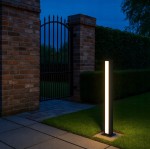 Czarna lampa ogrodowa Roma H60 w formie słupka, z dwoma źródłami LED 24W, o temperaturze barwowej 4000K. Zbliżenie na prostokątny kształt lampy, umieszczoną na trawniku obok płotu, w tle ciemne niebo.