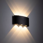 Kinkiet elewacyjny Arrow w kolorze czarnym, z sześcioma diodami LED 6W, o podwyższonej odporności IP54. Montowany na ścianie, emitujący ciepłe światło w kształcie łuku, tworzący efekt świetlnych refleksów na tle.