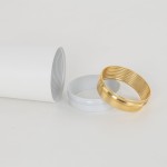 Biała lampa sufitowa Amis z oprawą na żarówkę GU10. Widoczny cylinder o gładkiej fakturze oraz dwa pierścienie: biały i złoty, przeznaczone do montażu. Całość na jasnym tle, ukazująca detale elementów.