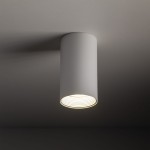 Lampa sufitowa Amis 1xGU10 w kolorze białym, cylindryczna, z widocznym kloszem z żłobieniami u góry. Zawieszona w pozycji pionowej, na jednolitym tle, emitująca ciepłe światło. Idealna do nowoczesnych wnętrz.