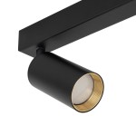 Lampa sufitowa Amis w kolorze czarnym z dwoma oprawami GU10. Cylindryczna forma z matowym wykończeniem, z widoczną złotą wewnętrzną częścią oprawy. Zamontowana na prostokątnej podstawie, w ujęciu z boku.