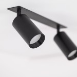 Lampa sufitowa podtynkowa Amis w kolorze czarnym z dwoma reflektorami GU10, zamontowana na prostokątnej podstawie. Reflektory mają cylindryczny kształt, umieszczone pod kątem, co umożliwia skierowanie światła w różnych kierunkach.