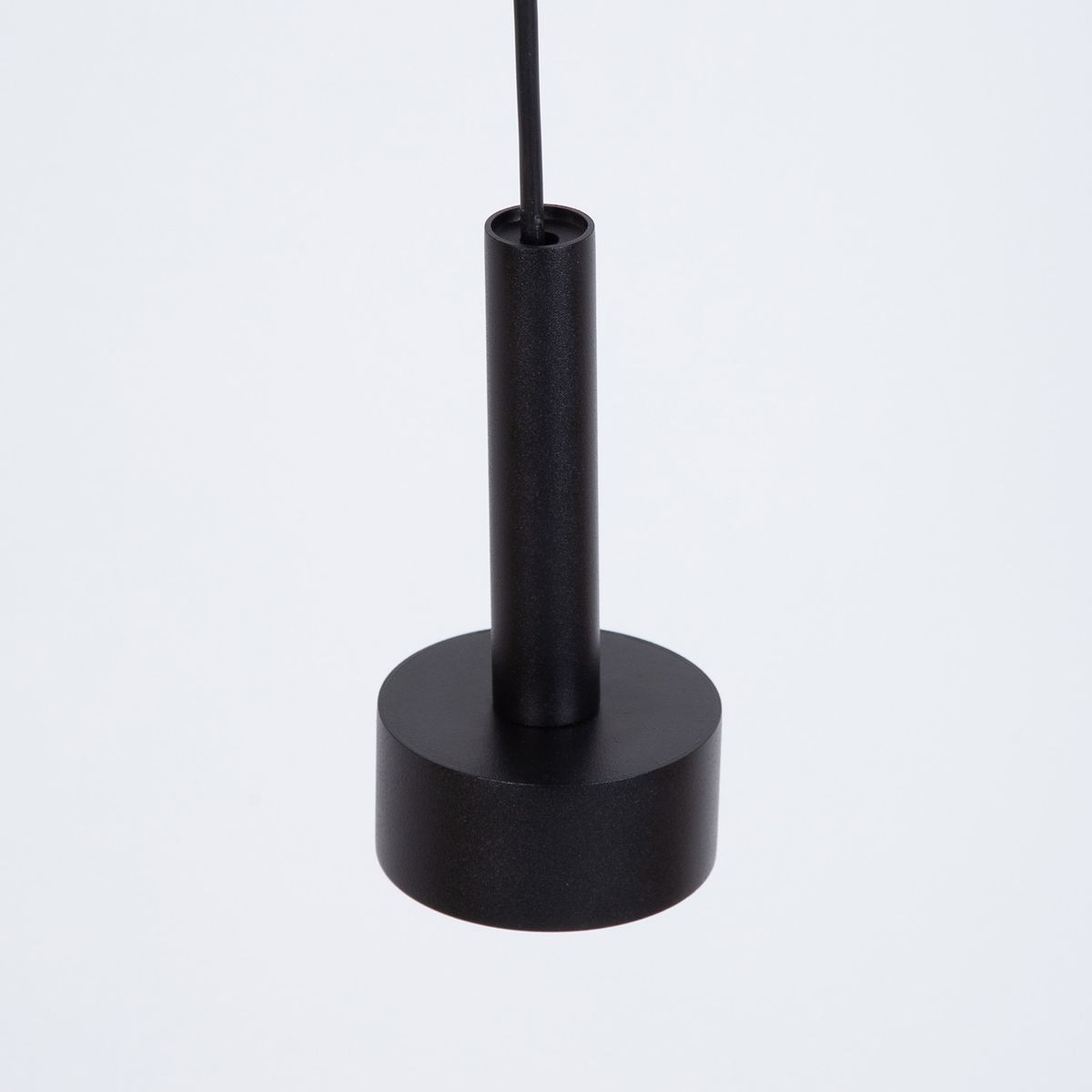 Lampa wisząca Stamp w kolorze czarnym, wyposażona w trzy gniazda GX53. Ujęcie z dołu, pokazujące cylindryczny uchwyt oraz okrągłą podstawę. Materiał matowy, minimalistyczny design, idealna do nowoczesnych wnętrz.
