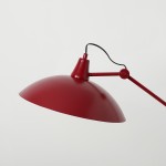 Lampa wisząca Melos w kolorze czerwonym z metalowym kloszem o półkulistym kształcie. Uchwyt i ramię w tym samym kolorze, z widocznym przewodem. Produkt zawieszony w górnej części, z możliwością regulacji kąta. Tło jasne, jednolite.