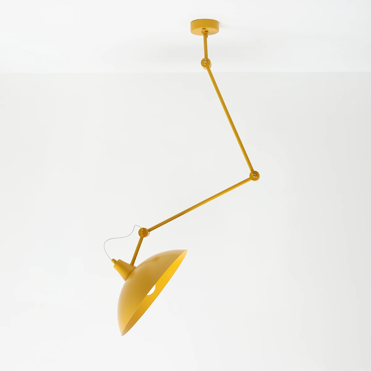 Lampa wisząca Melos 1xE27 w kolorze żółtym, z metalowym kloszem w kształcie stożka, zawieszona na regulowanym ramieniu. Produkt wisi pod kątem, z mocowaniem sufitowym w tej samej tonacji kolorystycznej, na białym tle.