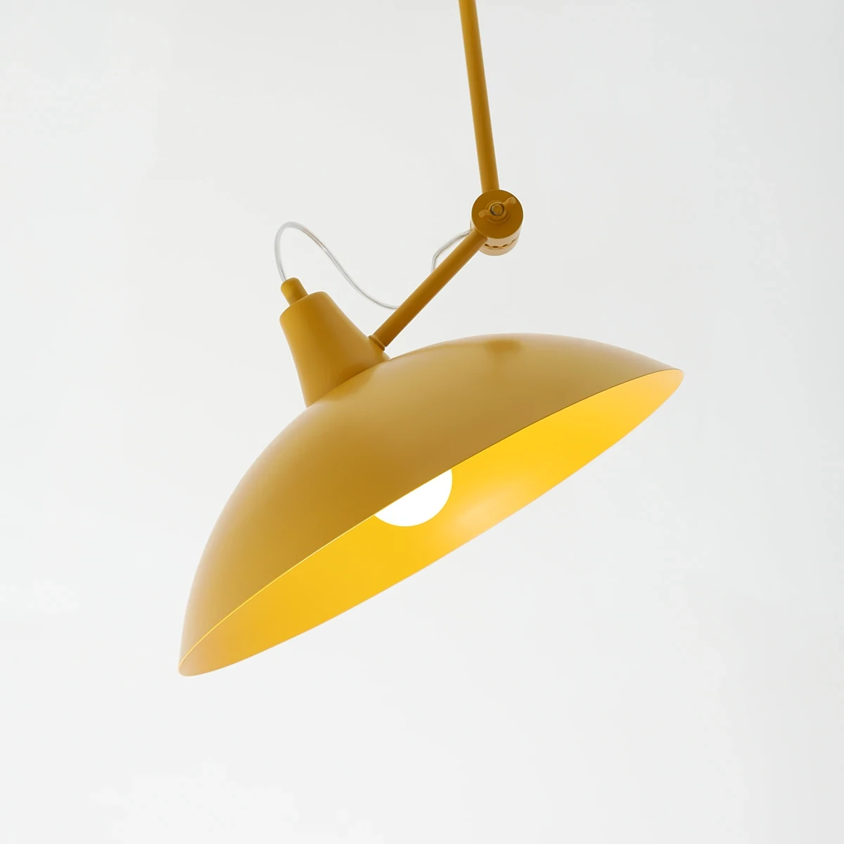 Lampa wisząca Melos 1xE27 w kolorze żółtym, z metalowym kloszem w kształcie stożka, zawieszona na cienkim przewodzie. Widoczny otwór w kloszu. Ujęcie z dołu, podkreślające kształt i detal konstrukcji. Tło białe, minimalistyczne.