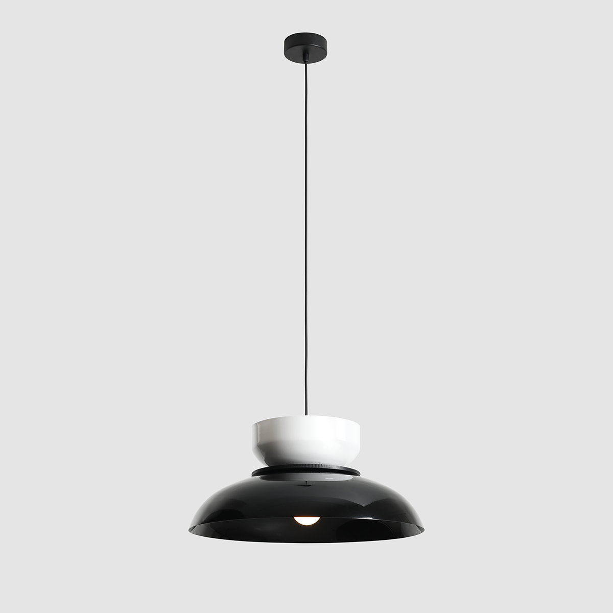 Lampa wisząca Aldo 1xE27 w kolorze czarnym i białym, z okrągłym kloszem w dolnej części oraz białym elementem na górze. Zawieszona na czarnym przewodzie, widok frontalny na prosty, nowoczesny design.