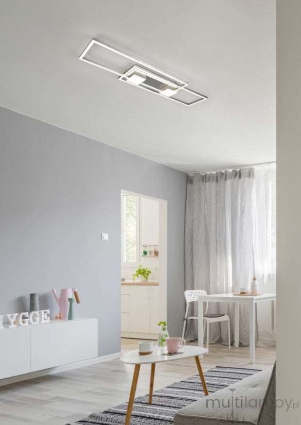 Lampa sufitowa Albany z pilotem LED/37W w kolorze nikiel, zamontowana na suficie, o prostokątnym kształcie. W tle widoczna jasna aranżacja wnętrza z białymi meblami i zasłonami.