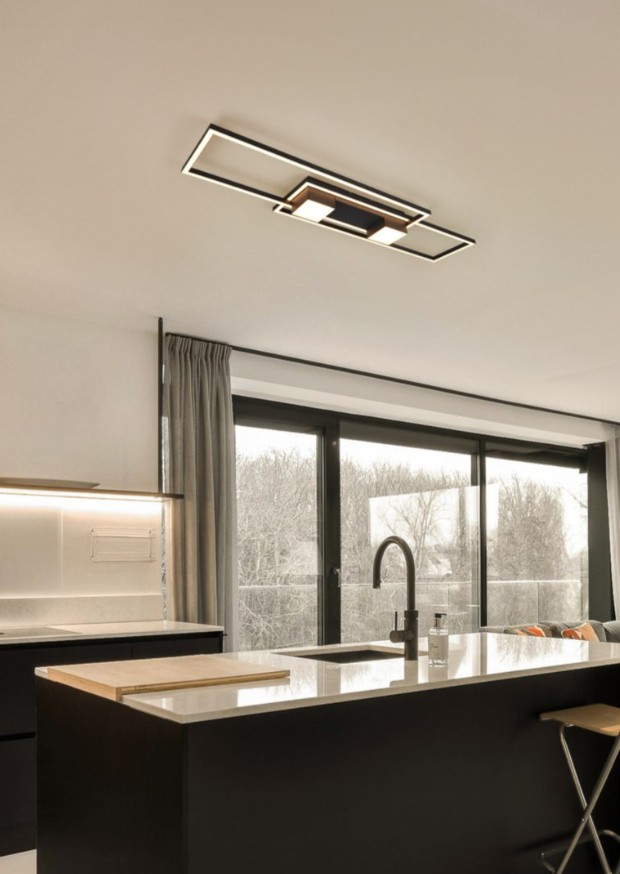 Czarna lampa sufitowa LED Albany o mocy 37W z pilotem, zamontowana na suficie, z nowoczesnym, prostokątnym designem. Widoczna w kuchni z dużymi oknami, na tle jasnych mebli i blatu.