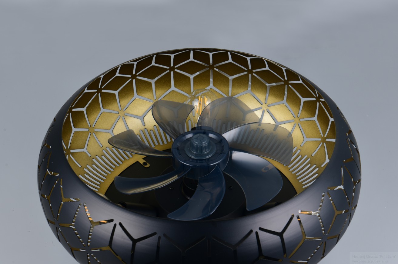 Bidar lampa sufitowa z wentylatorem w kolorze czarnym, z metalowym abażurem o złotym wnętrzu i geometrycznym wzorem. Widać przezroczyste łopaty wentylatora. Produkt widoczny z góry, prezentujący detal wentylatora i wzór abażuru.