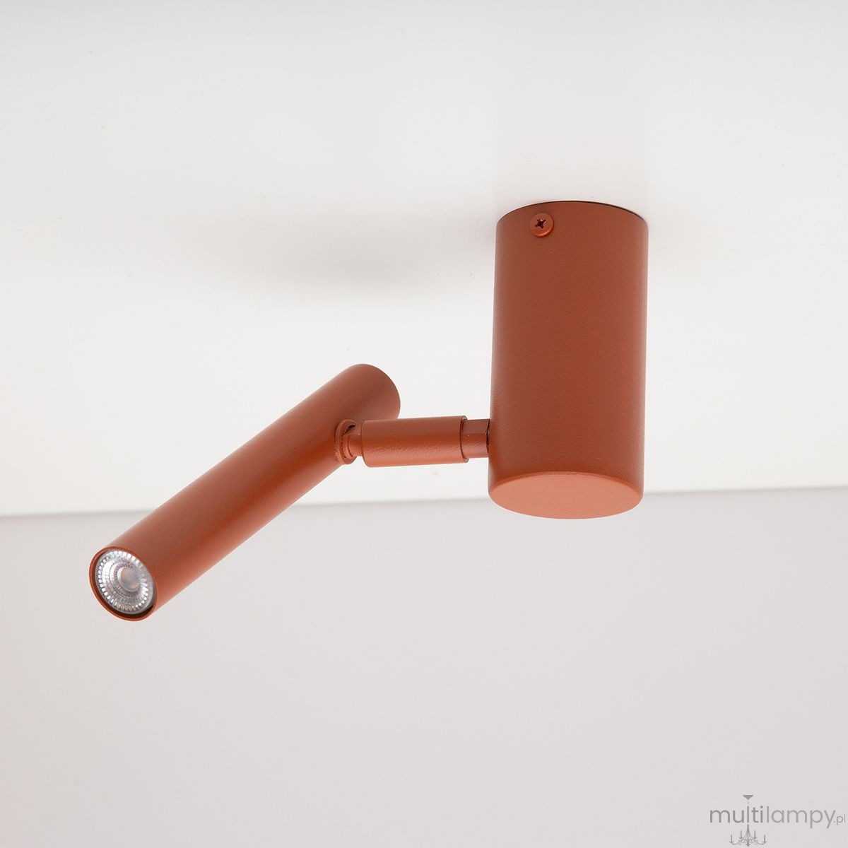 Krótka lampa sufitowa (spot) w kolorze ceglastym, z regulowanym ramieniem, jedną oprawą na żarówkę G9. Ujęcie z boku, montowana do sufitu, z widoczną teksturą matowego wykończenia.