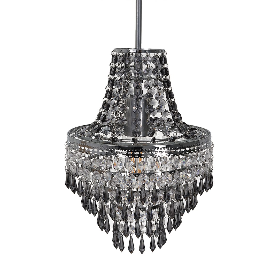 Lampa wisząca Gemma w kolorze chromu z pojedynczym gniazdem E27. Ozdobiona kryształowymi wisiorkami o różnych kształtach, zwisająca w kształcie stożka. Widoczna elegancka dekoracja z długimi, wiszącymi elementami.