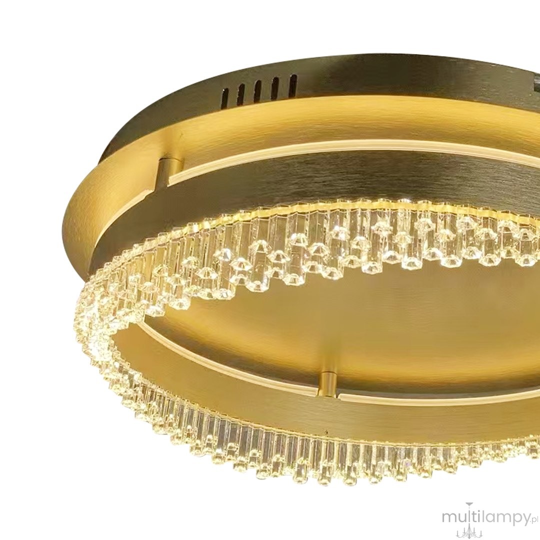 Złota lampa sufitowa LED 36W 4000K z kryształowymi detalami, okrągła konstrukcja, z widocznym pierścieniem oświetleniowym oraz dekoracyjnymi elementami w formie wiszących kryształów. Ujęcie z dołu, eksponujące elegancki design.