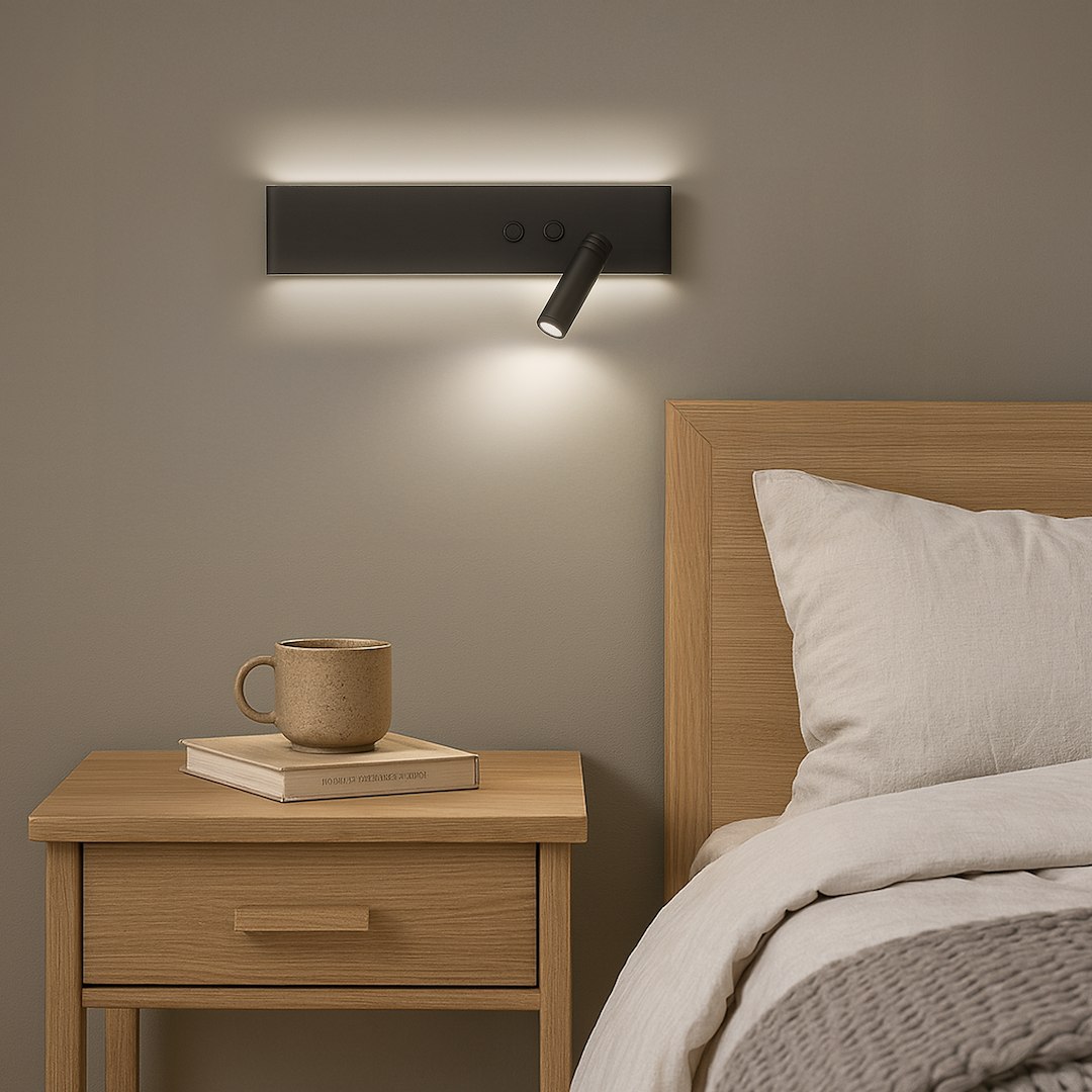 Kinkiet LED Resort Right w kolorze czarnym, moc 10W+3W, temperatura barwowa 4000K. Ujęcie frontalne, zamontowany na ścianie nad nocną szafką. Obok filiżanka i książka. Wbudowane przyciski na obudowie kinkietu, emitujący ciepłe światło.