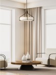Lampa wisząca Doretto Chocco D50 w brązowym kolorze, z trzema miejscami na żarówki E27. Ma geometryczny kształt z metalowym stelażem i okrągłym kloszem. Zawieszona w jasnym wnętrzu, nad okrągłym drewnianym stołem.
