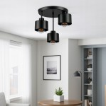 Lampa sufitowa Elza z trzema oprawami E27 w kolorze czarnym, zawieszona na okrągłej podstawie. Widoczne są trzy cylindryczne klosze z przezroczystymi żarówkami, umieszczone pod kątem w nowoczesnym wnętrzu.