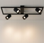 Czarna lampa sufitowa Bumo z czterema reflektorami na prostokątnej podstawie. Reflektory skierowane w dół, z okrągłymi kloszami. Lampa montowana na suficie, w minimalistycznym stylu, idealna do nowoczesnych wnętrz. Tło jasne, gładkie.