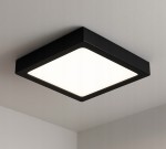 Panel LED natynkowy w kształcie kwadratu, o wymiarach D21x21 cm, 18W, barwie światła 4000K. Posiada czarną ramkę i matową, białą powierzchnię emitującą światło, zamontowany na suficie w prostym otoczeniu.
