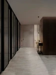 Czarna lampa wisząca Achocalla z jedną diodą LED 5W, zawieszona na cienkim przewodzie w eleganckim wnętrzu. Widoczna w nowoczesnym korytarzu z szklanymi ściankami i minimalistycznym meblem.
