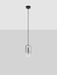 Czarna lampa wisząca Anuco z jedną żarówką LED 3W, z cylindrycznym, transparentnym kloszem. Wisi na cienkim, czarnym kablu, montowana do sufitu. Tło jasnoszare, podkreślające minimalistyczny design.