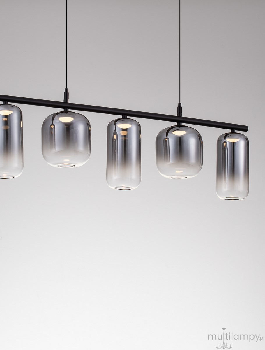 Lampa wisząca Anuco z pięcioma kloszami LED 19W, czarna. Klosze w kształcie cylindrów z przezroczystego szkła, zawieszone na cienkiej metalowej rurze. Ujęcie frontalne, na jednolitym tle.