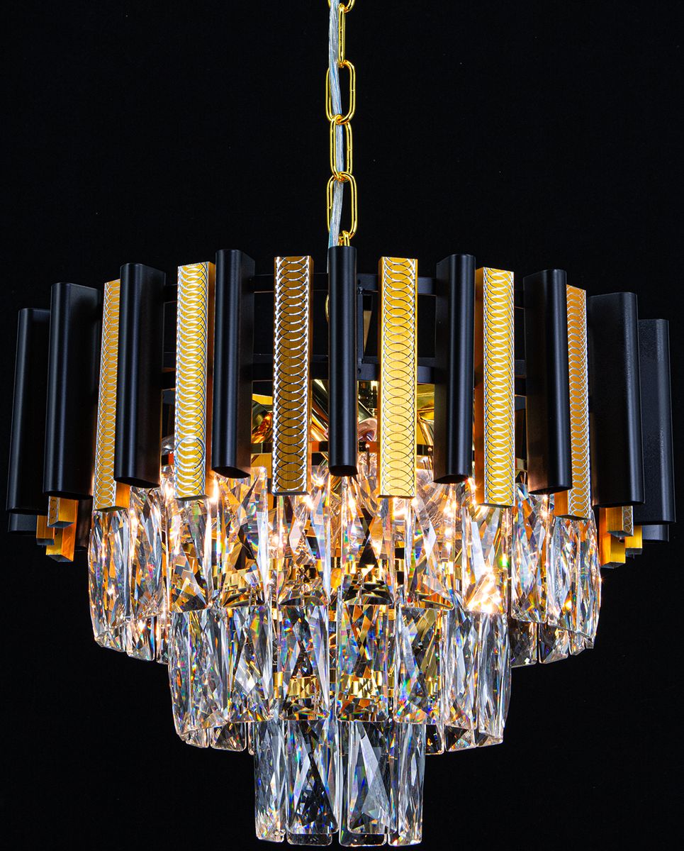Lampa wisząca Bilbao 4xE27 w kolorze złotym i czarnym, z geometrycznymi elementami oraz kryształowymi kloszami. Ujęcie z dołu, pokazujące detal i strukturę lampy, zawieszonej na złotym łańcuchu, na czarnym tle.