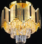 Lampa sufitowa Belize 4xE27 w kolorze złotym i czarnym. Konstrukcja z metalowych, prostokątnych elementów oraz kryształowe wiszące detale tworzą elegancki efekt. Widok z góry, lampa zamontowana na suficie, emitująca ciepłe światło.