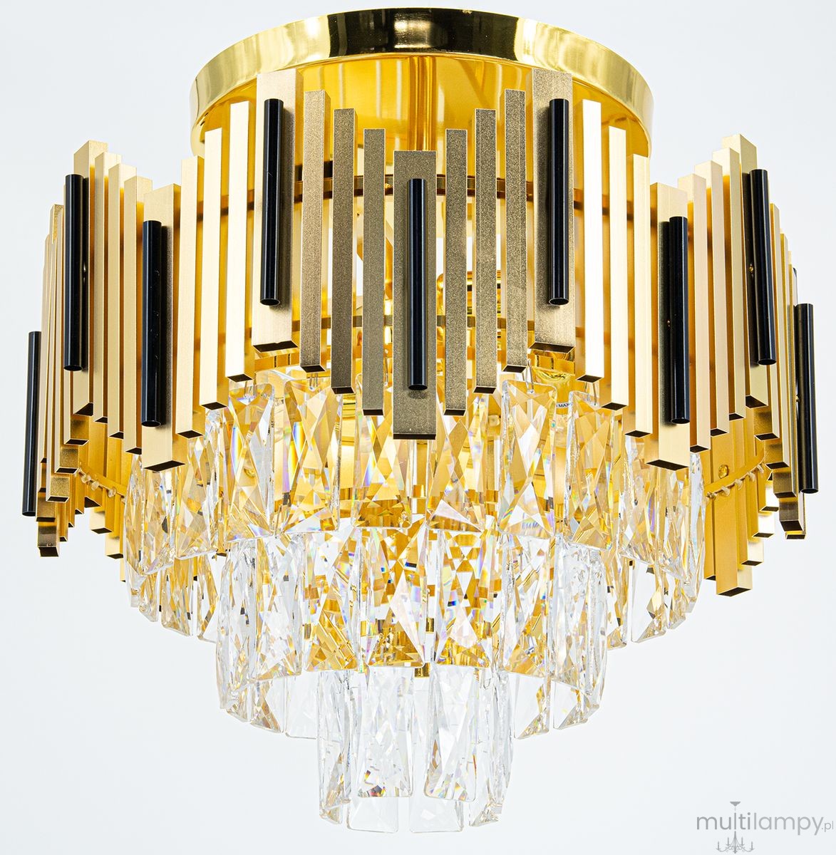 Lampa sufitowa Belize 4xE27 w kolorze złotym i czarnym, z metalową podstawą oraz dekoracyjnymi elementami w formie prostokątnych szczebli. Poniżej widoczne kryształowe elementy w kształcie brył, odbijające światło. Ujęcie z góry, produkt wiszący.