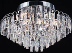 Lampa sufitowa Monaco w chromowanej obudowie, z sześcioma miejscami na żarówki E27. Posiada kryształowe elementy w formie wiszących, prostokątnych dekoracji, które odbijają światło, tworząc efektowną iluminację. Ujęcie z dołu, na jednolitym tle.