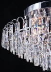 Lampa sufitowa Monaco 6xE27 w kolorze chromu, z kryształowymi elementami w kształcie prostokątów i trójkątów, zawieszona na metalowym stelażu. Ujęcie z dołu, ukazujące szczegóły kryształów i źródeł światła.