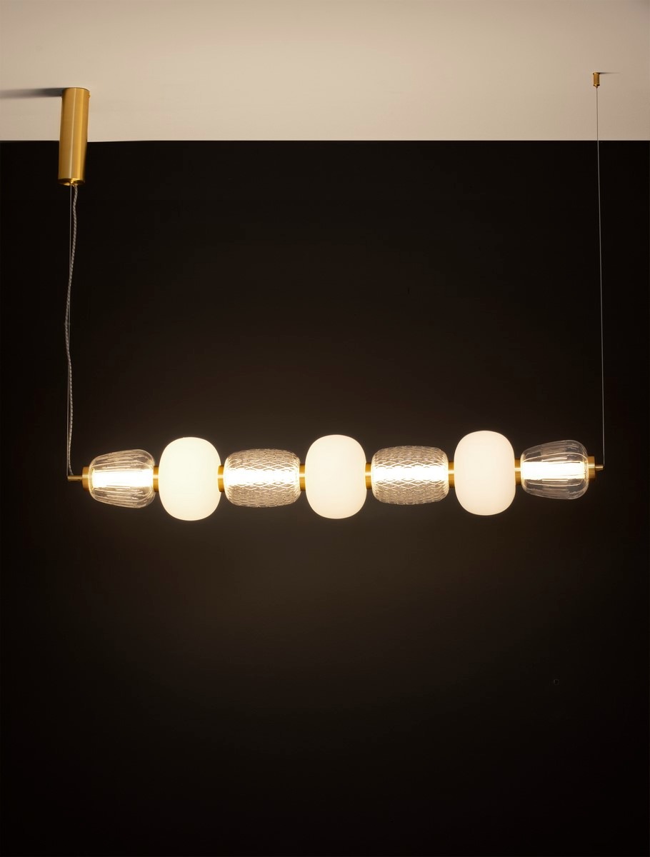 Lampa wisząca Arroyos 1xLED 42W w kolorze złotym, z sześcioma okrągłymi i cylindrycznymi kloszami, z przezroczystego i matowego szkła. Zawieszona na cienkim drucie, z montażem sufitowym, na jednolitym, ciemnym tle.