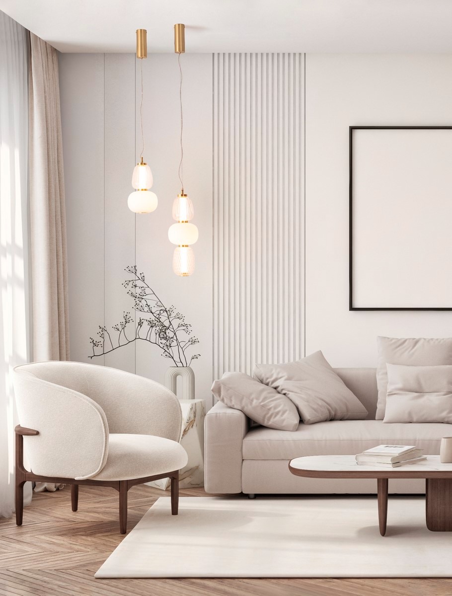 Lampa wisząca Arroyos 1xLED 28W w kolorze złotym, składająca się z trzech okrągłych kloszy w różnych rozmiarach. Zawieszona na cienkich linkach, w nowoczesnym wnętrzu z jasnymi meblami i minimalistycznym tłem.