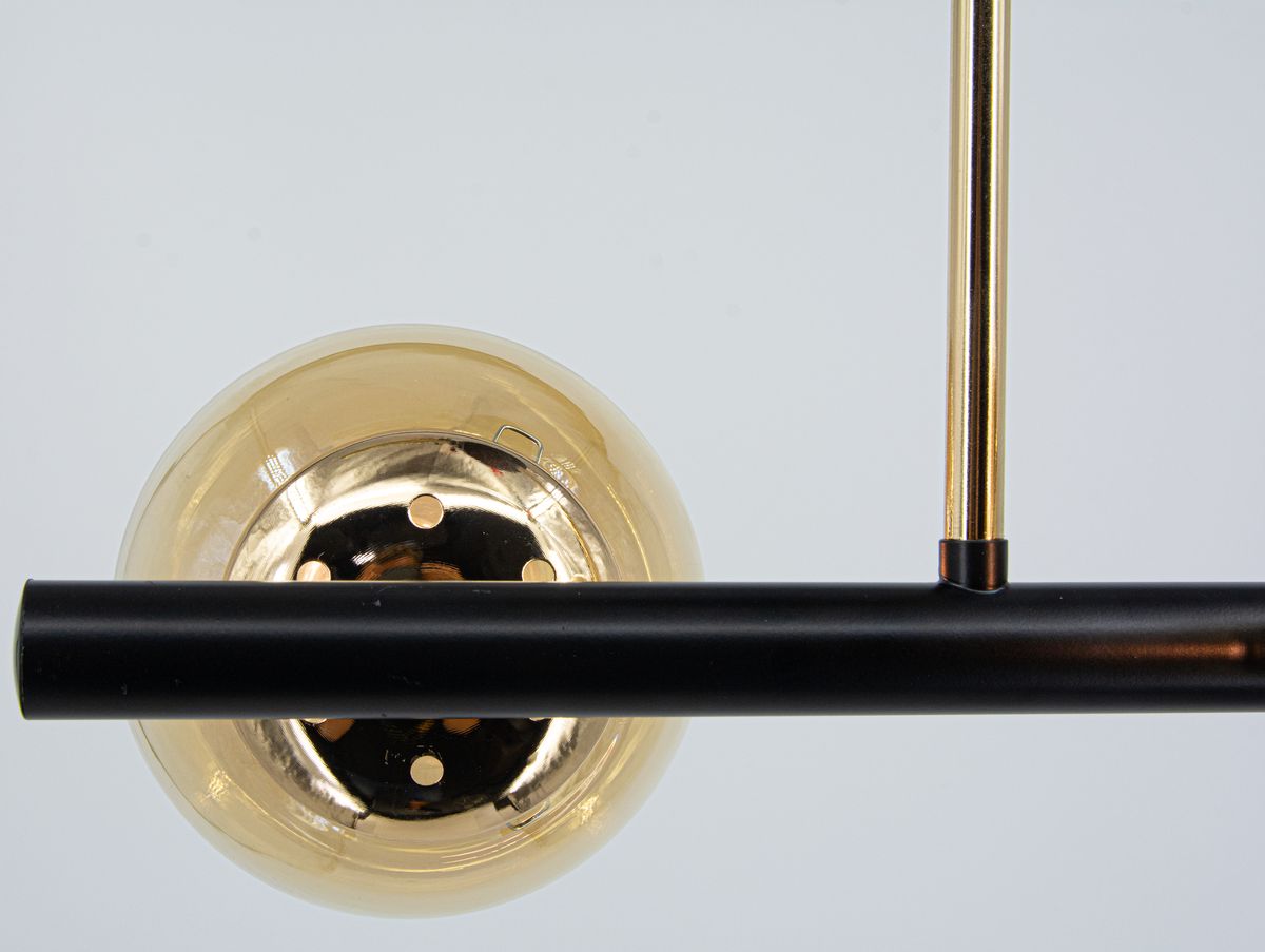 Lampa wisząca Otis w kolorze czarnym i złotym, z opalowym kloszem w kształcie kuli, zamontowana na prostokątnym ramieniu. Widać dwa miejsca na żarówki E27. Produkt ukazany z góry, na jasnym tle.