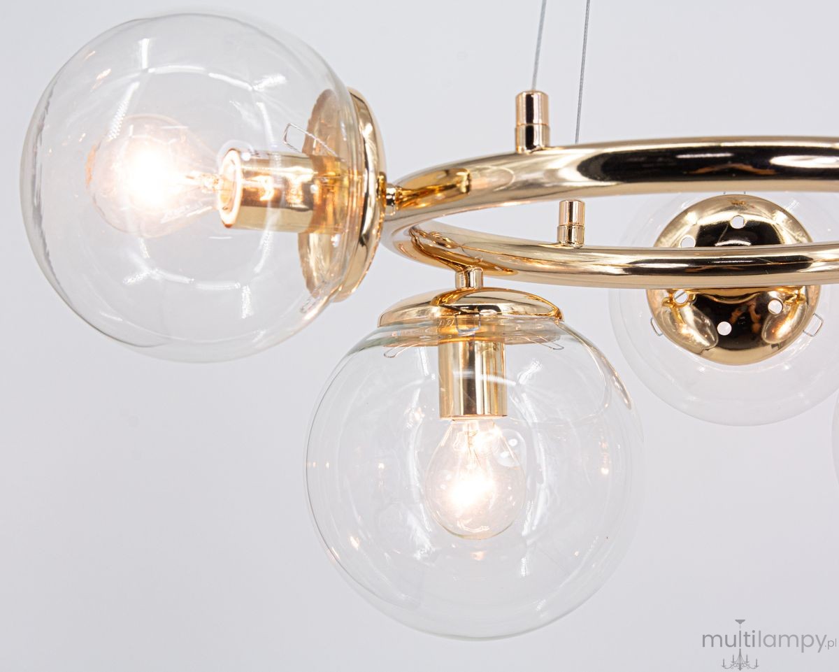 Lampa wisząca Amaro 5xE14 w kolorze złotym. Posiada pięć przezroczystych kloszy w kształcie kul, zawieszonych na złotej metalowej konstrukcji. Ujęcie z bliska, ukazujące detale wykończenia i źródeł światła. Tło białe.