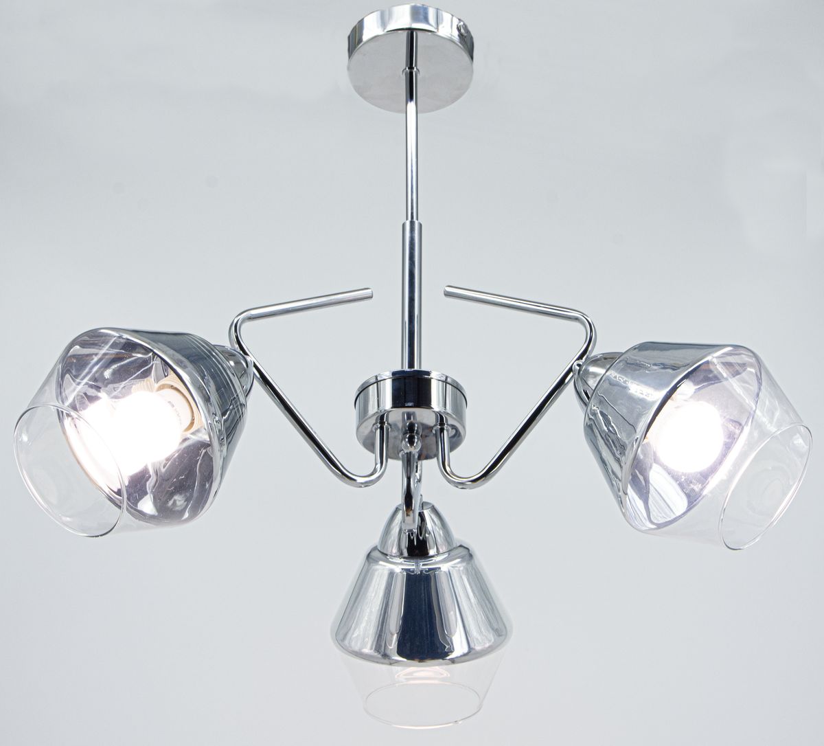 Żyrandol Clovis 3xE27 w chromowanym wykończeniu, z trzema kloszami w kształcie stożków. Klosze wykonane z przezroczystego materiału, zamontowane na metalowej konstrukcji. Całość zawieszona na prostym, chromowanym stelażu.