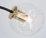 Lampa sufitowa Elba 4xE27 w kolorze czarnym i złotym z przezroczystym kloszem. Widok z góry na detal oprawy, metalowy element w złotym wykończeniu z żarówką wewnątrz, zawieszona na czarnym przewodzie.